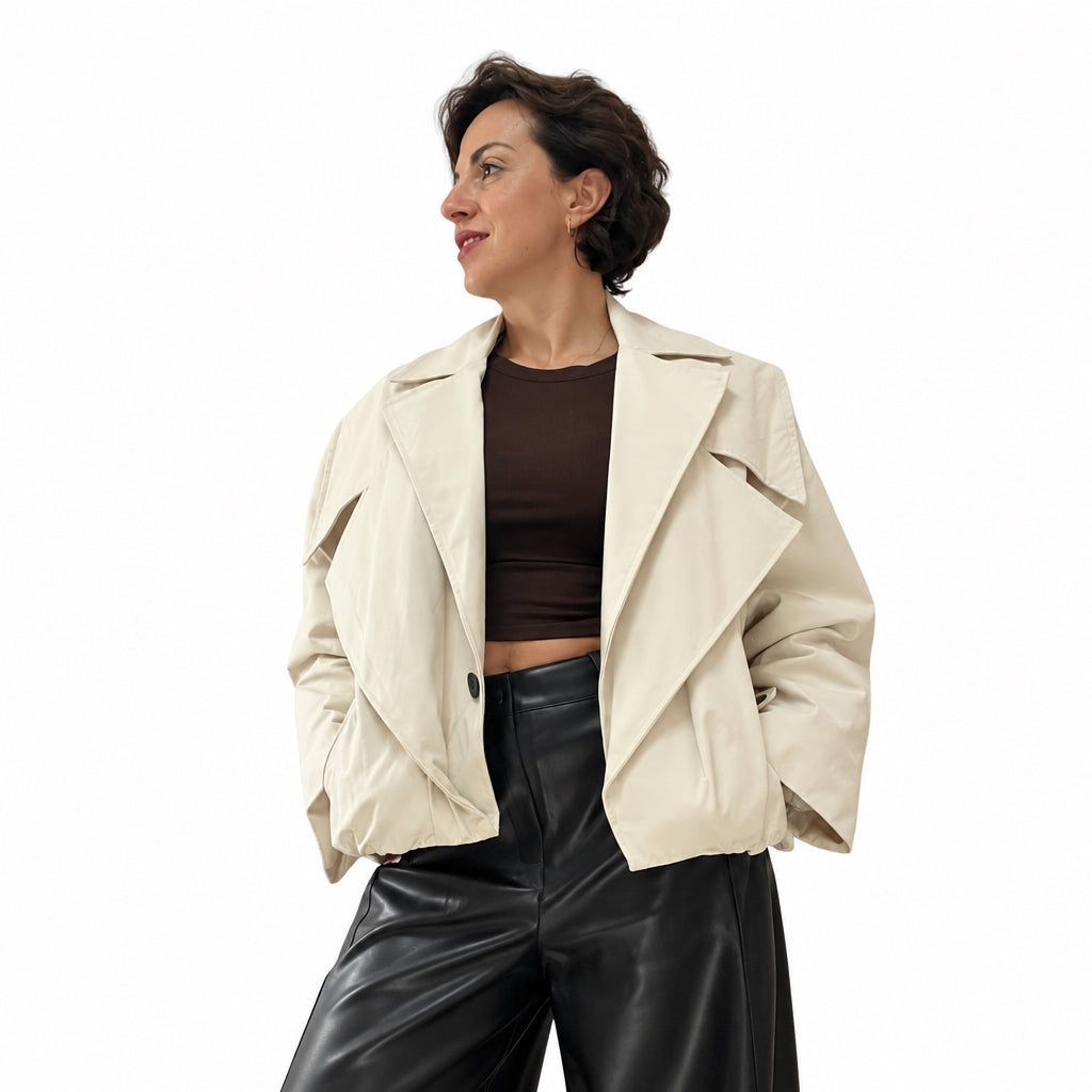 Modella indossa giacca corta oversize color crema con ampi revers di Caldea Boutique su top marrone e pantaloni neri
