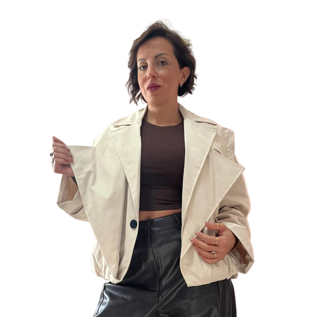 Modella indossa giacca corta oversize color crema con ampi revers di Caldea Boutique sopra un top marrone e pantaloni