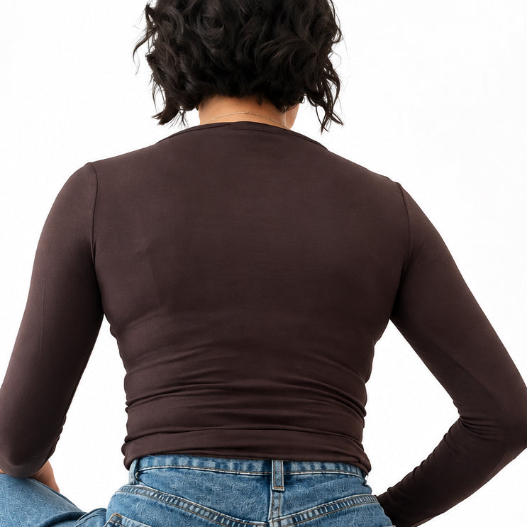 Modella indossa maglia a maniche lunghe Caldea Boutique testa di moro aderente con jeans in camerino